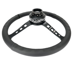 NRG Innovations Reinforced Steering Wheel - Fuguz x NRG collaboration 1.5" Deep, 5mm matte black spoke, 380mm Sport Steering Wheel Black leather w/ black stitching iconic episode 2 laser engraving RST-380SK-EP2